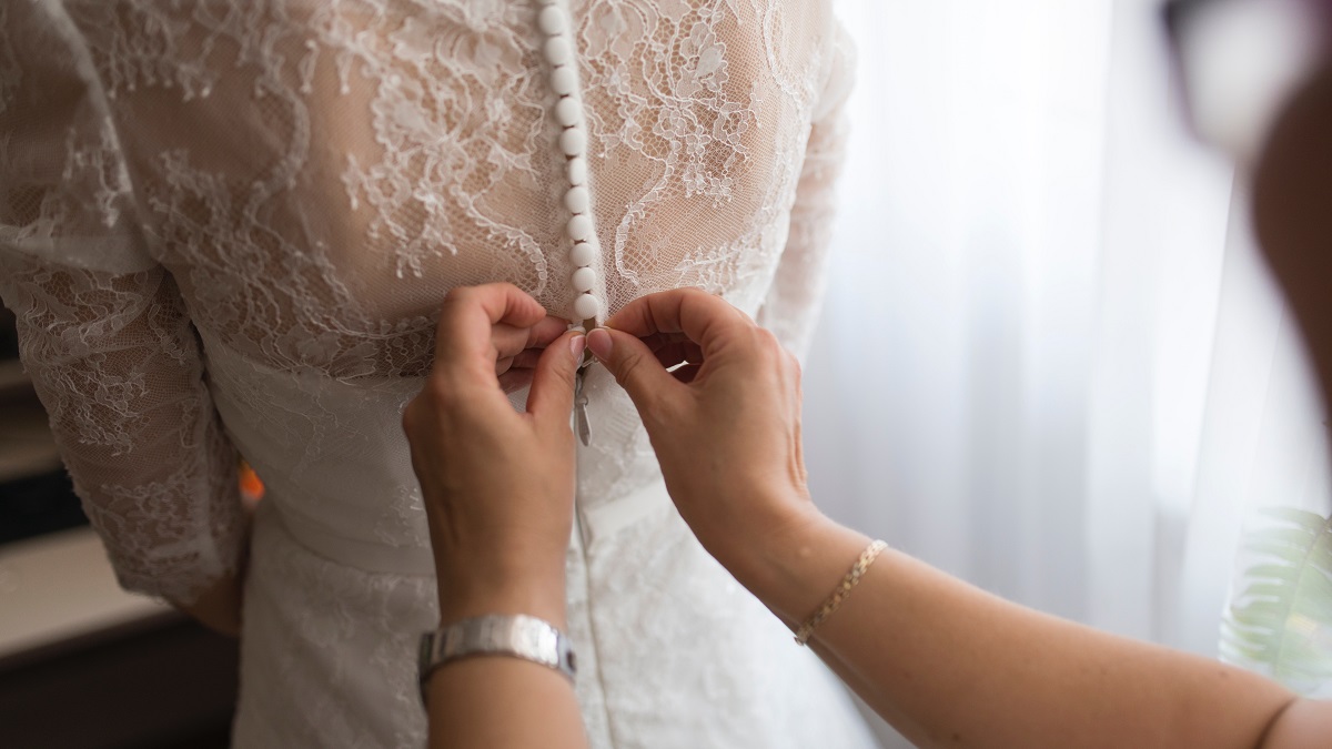 Braut bekommt Hilfe beim Anziehen